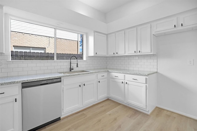 kitchen with sink, light hardwood / wood-style flooring, dishwasher, white cabinetry, and tasteful backsplash