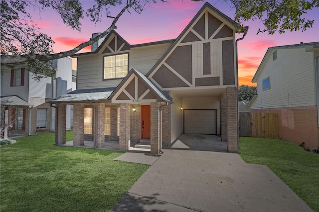 tudor home with a garage and a lawn