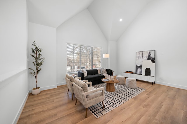 living room with high vaulted ceiling and light hardwood / wood-style floors