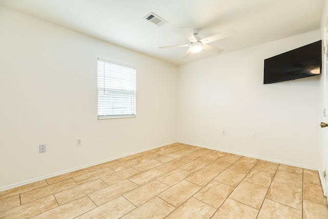 spare room with ceiling fan and light tile patterned flooring