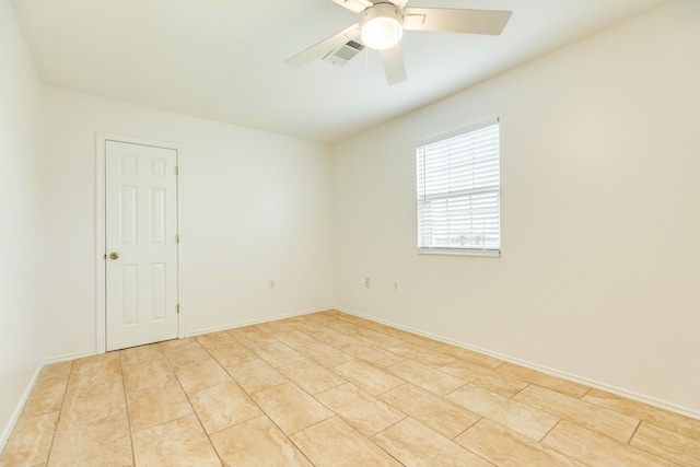 tiled spare room with ceiling fan