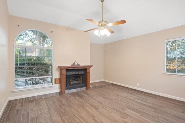 unfurnished living room featuring wood-type flooring and ceiling fan