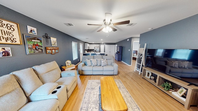 living room with light hardwood / wood-style floors and ceiling fan