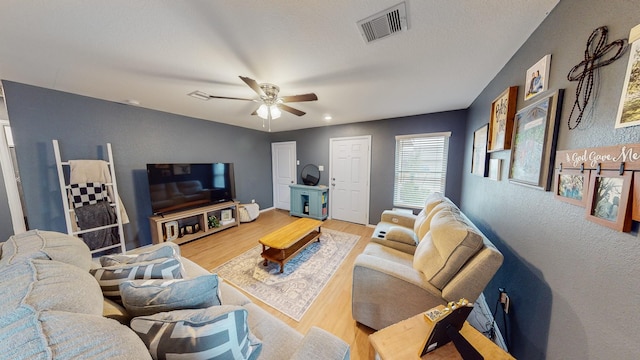 living room featuring ceiling fan and hardwood / wood-style floors