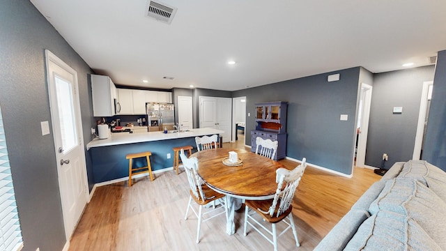 dining area with sink and light hardwood / wood-style floors