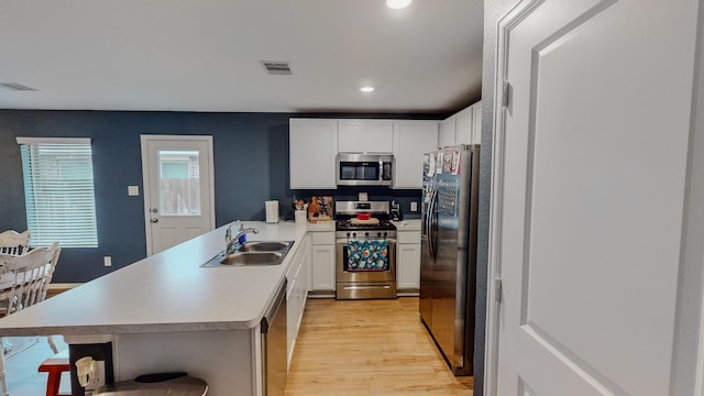 kitchen featuring white cabinetry, sink, stainless steel appliances, and light wood-type flooring