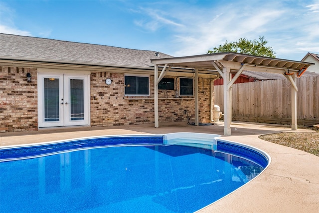 view of swimming pool featuring french doors and a patio