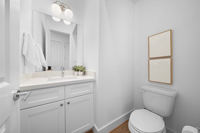 bathroom with hardwood / wood-style flooring, vanity, and toilet