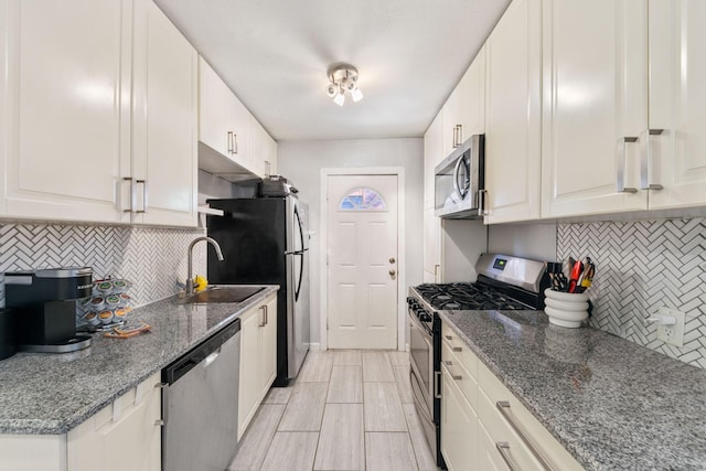 kitchen featuring white cabinetry, dark stone counters, and appliances with stainless steel finishes