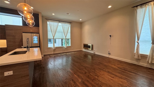 interior space with heating unit, sink, and dark hardwood / wood-style floors