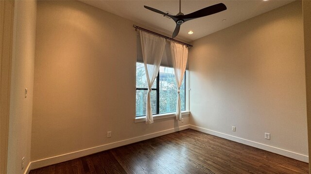 spare room with dark wood-type flooring and ceiling fan