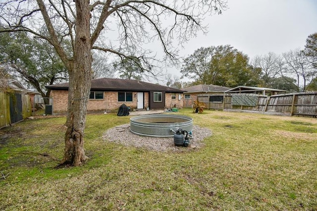 back of property with a swimming pool and a lawn