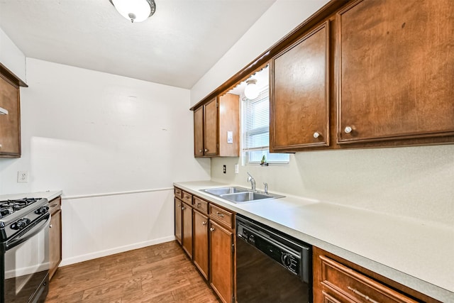 kitchen featuring sink, light hardwood / wood-style flooring, and black appliances