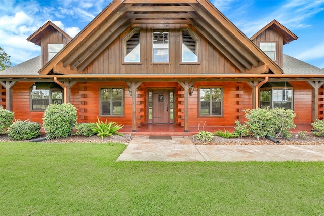 view of front of house with a front yard and covered porch