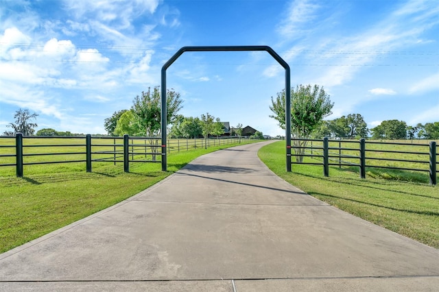 view of gate with a rural view and a yard