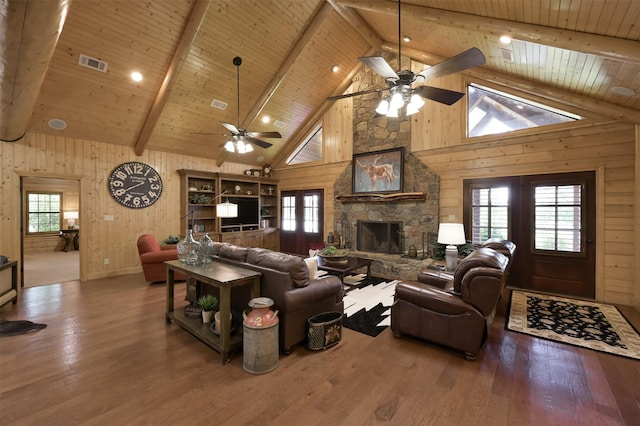 living room with hardwood / wood-style flooring, plenty of natural light, wood walls, and beamed ceiling