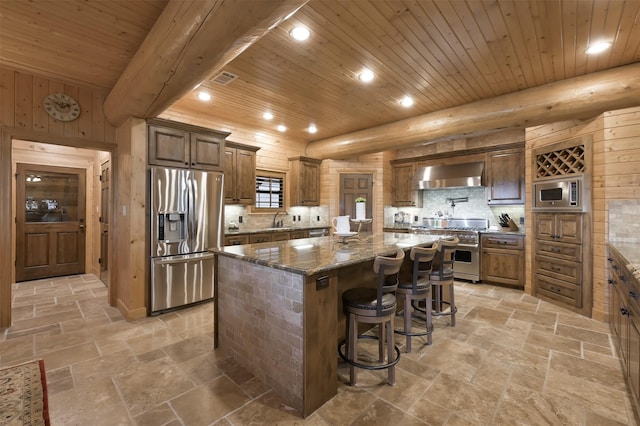 kitchen featuring a large island, wood ceiling, a breakfast bar, appliances with stainless steel finishes, and wall chimney exhaust hood