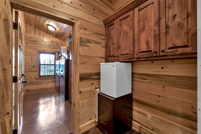 laundry area featuring wooden ceiling and wood walls