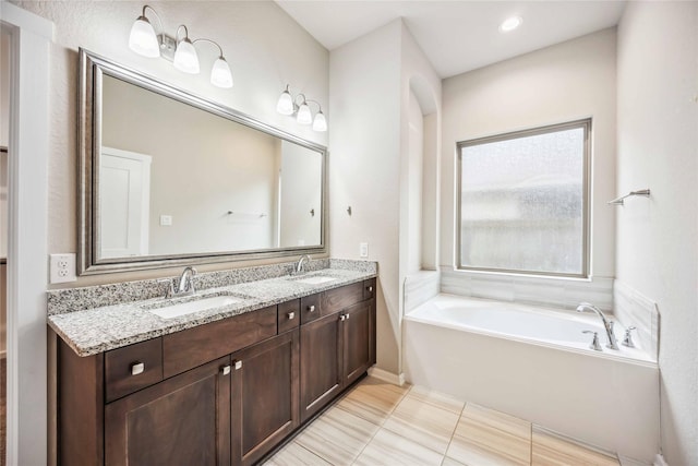 bathroom with vanity and a bath