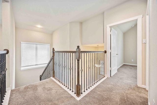 corridor featuring light carpet and lofted ceiling