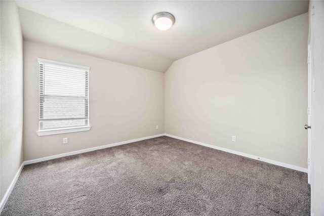 carpeted spare room with lofted ceiling