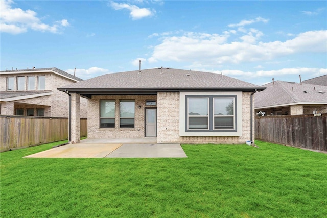 rear view of house with a lawn and a patio