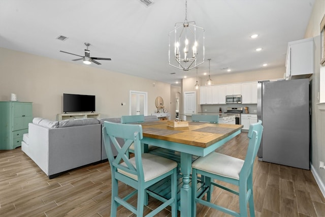 dining room with ceiling fan with notable chandelier