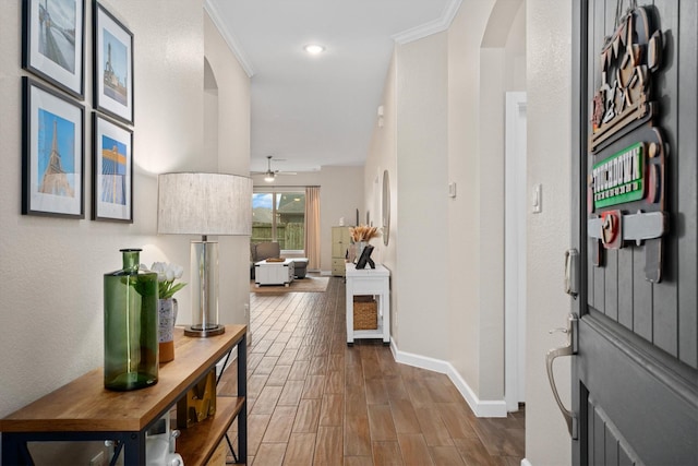 foyer entrance with crown molding, ceiling fan, and wood-type flooring