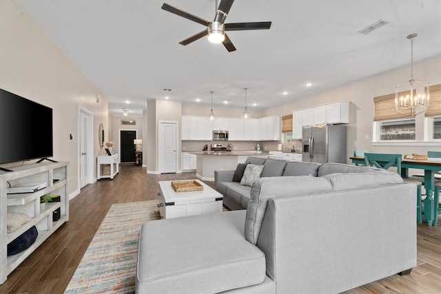 living room featuring hardwood / wood-style flooring and ceiling fan with notable chandelier