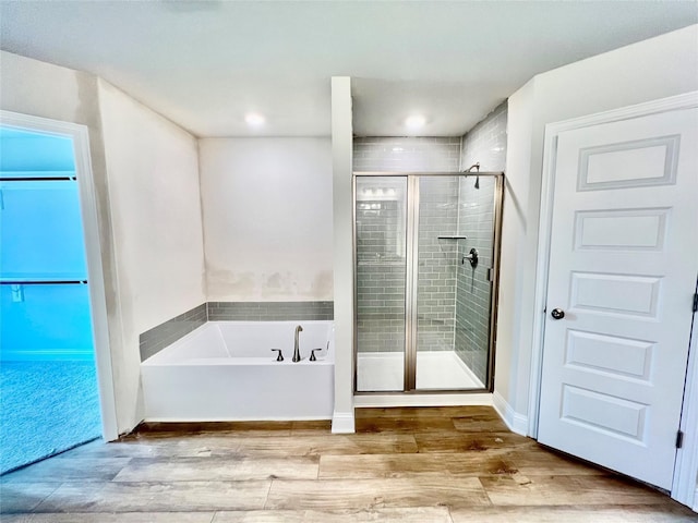 bathroom with shower with separate bathtub and hardwood / wood-style floors