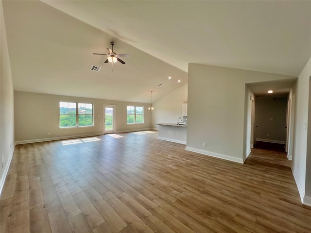 unfurnished living room featuring ceiling fan, sink, high vaulted ceiling, and light hardwood / wood-style flooring