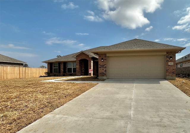 ranch-style home with a garage, brick siding, fence, concrete driveway, and roof with shingles