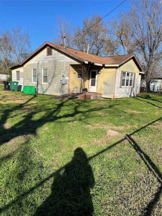 back of house featuring a lawn