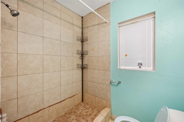 bathroom with toilet and tiled shower