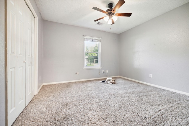 unfurnished bedroom with ceiling fan, a closet, carpet, and a textured ceiling