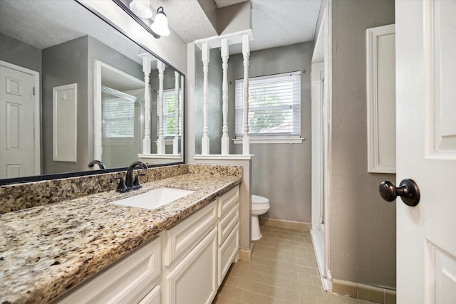 bathroom with vanity, tile patterned floors, a textured ceiling, and toilet