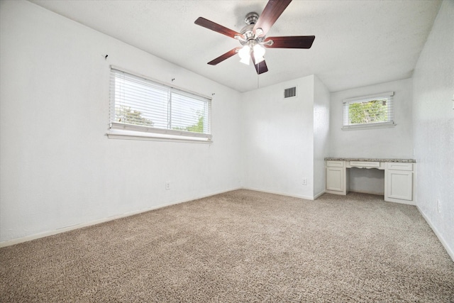 unfurnished bedroom featuring multiple windows, light carpet, and ceiling fan