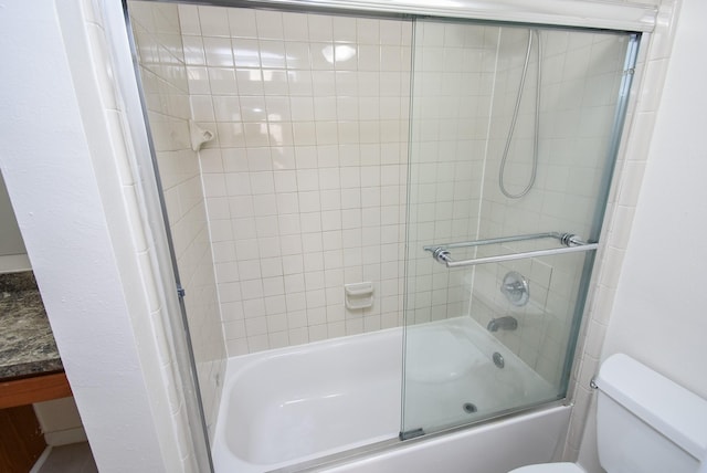 full bathroom with toilet, vanity, and bath / shower combo with glass door