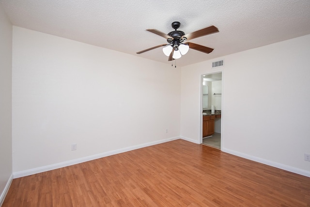 empty room featuring ceiling fan, wood-type flooring, and a textured ceiling