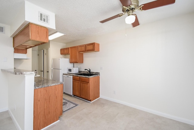 kitchen featuring ceiling fan, sink, a textured ceiling, and white appliances