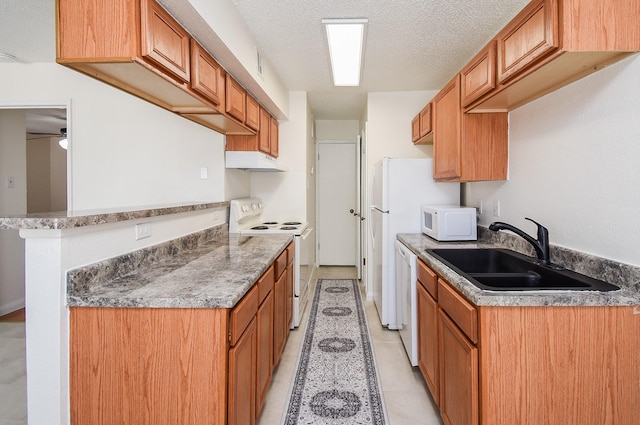 kitchen featuring sink, light tile patterned floors, a textured ceiling, and white appliances