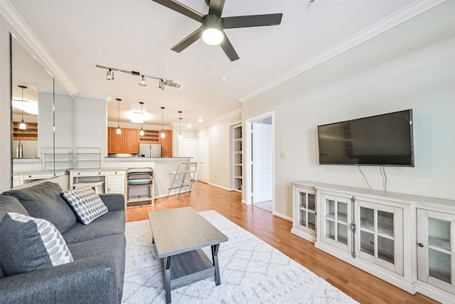 living room with ornamental molding, light hardwood / wood-style floors, rail lighting, and ceiling fan