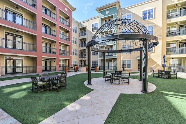 view of home's community with a patio and a lawn