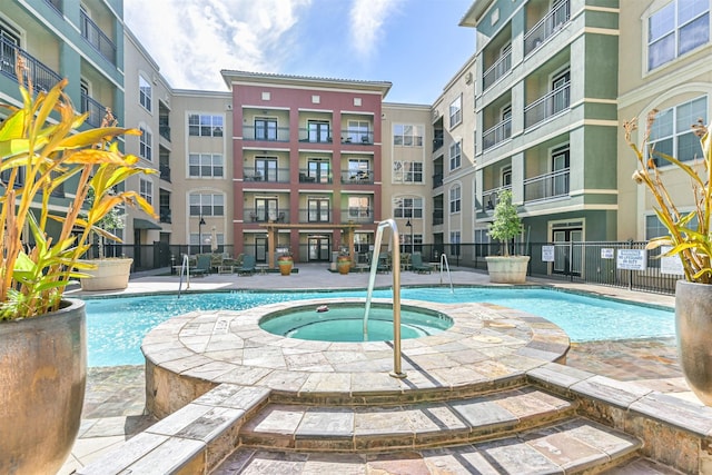 view of pool featuring a community hot tub and a patio