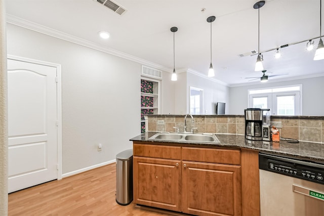 kitchen with crown molding, sink, stainless steel dishwasher, and decorative light fixtures