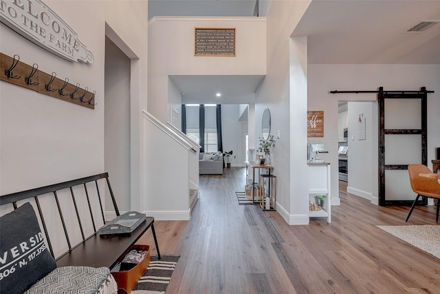 foyer featuring light wood-type flooring and a barn door