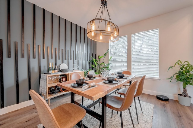 dining area featuring light hardwood / wood-style floors and a notable chandelier