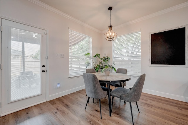 dining space featuring light hardwood / wood-style floors, a chandelier, and ornamental molding