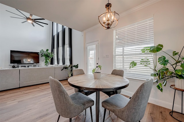 dining space featuring crown molding, a notable chandelier, and light hardwood / wood-style flooring