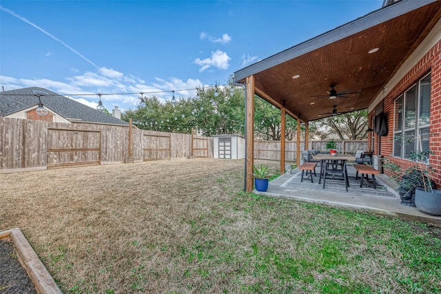 view of yard with a storage unit, ceiling fan, and a patio area